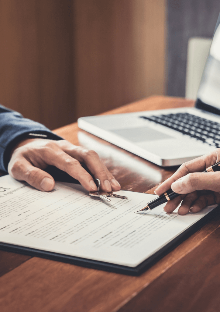 Zoom sur une main tenant un stylo entrain de signer un contrat